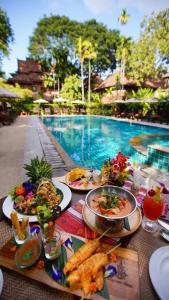 
a table topped with plates of food and drinks at Yaang Come Village Hotel - SHA Extra Plus in Chiang Mai
