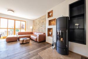 uma sala de estar com um frigorífico preto e um sofá em Ferienhaus „Adlerhorst“ eignet sich ideal für die ganze Familie em Garmisch-Partenkirchen