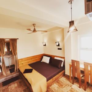a bedroom with a bed and a ceiling fan at Little Island (Beach Cafe & Guest House) in Mahabalipuram