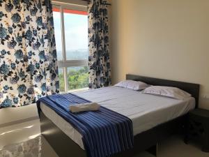a bedroom with a bed with a window with curtains at seaview Apartment in Nārāinpur