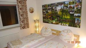 ein Schlafzimmer mit zwei Betten und einem Gemälde an der Wand in der Unterkunft Pension "Am Schloß" in Lübben