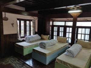 een kamer met 3 bedden in een kamer met ramen bij Yog Hostel- Rooftop Yoga & Backpacker Social Stay in Thamel, Kathamndu in Kathmandu
