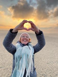 a woman is making a heart shape with her hands at Hotel José in Blankenberge