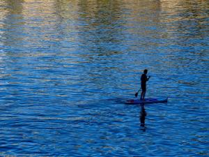 a man standing on a paddle board in the water at Villa Kamen Green in Vela Luka