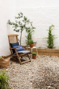 una silla, una mesa y un árbol en un patio en CASA FILOMENA, en Barcelona