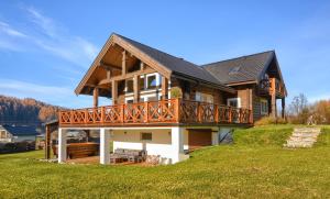 a large house with a deck on a hill at CHATA POD PRZEHYBĄ in Stary Sącz