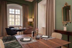 a dining room with a table and chairs and a window at Boutique Hotel Zum Oberjäger, Schloss Lackenbach in Lackenbach