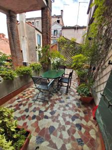 un patio con mesa y sillas en un suelo de baldosa en A PRIVATE TERRACE IN THE HEART OF VENICE, en Venecia
