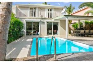 une villa avec une piscine en face d'une maison dans l'établissement Villa Magellan, walkable Orient Bay beach, private pool, à La Baie-Orientale