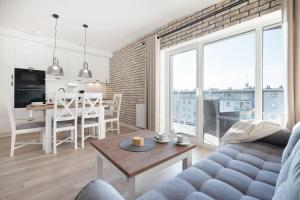 a living room with a couch and a table at Apartamenty Słoneczne Tarasy by Renters in Dziwnówek