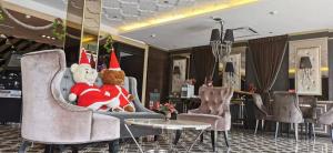 a teddy bear wearing a santa hat sitting in a chair at Hermess Hotel Johor in Johor Bahru
