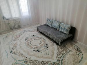 a living room with a couch and a rug at Уют в Авангарде in Atyraū