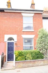 a red brick house with a blue door at Little Lane in Alverstoke