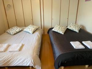 two beds sitting next to each other in a room at ETERNITY Tamatsukuri 301 in Osaka