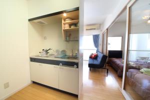 a kitchen and a living room with a couch at ETERNITY Tamatsukuri 401 in Osaka