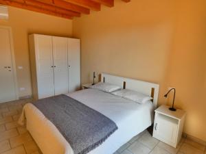 ヴァレッジョ・スル・ミンチョにあるAgriturismo il Fontanileのベッドルーム(白いベッド1台、白いキャビネット付)