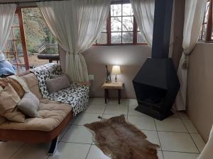a living room with a couch and a fireplace at The Old Hatchery in Underberg