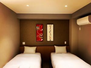 Postel nebo postele na pokoji v ubytování ikoi HOTEL