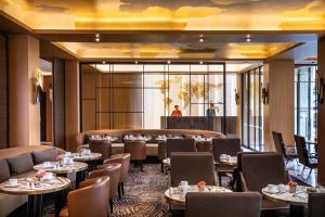 a restaurant with tables and chairs and people in the background at Hotel Maison FL in Paris