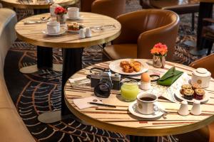 two tables in a restaurant with food on them at Hotel Maison FL in Paris
