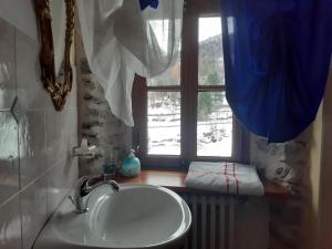 ein Bad mit einem Waschbecken und einem Fenster in der Unterkunft B&B Alpe Veglia in Varzo