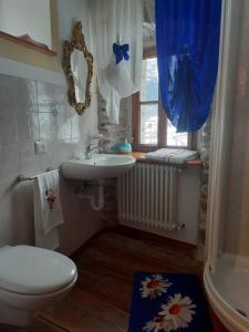 ein Bad mit einem Waschbecken, einem WC und einem Fenster in der Unterkunft B&B Alpe Veglia in Varzo