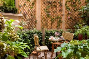 a patio with a table and chairs and plants at Hotel Maison FL in Paris