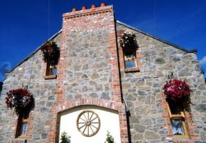 una iglesia de piedra con cestas de flores en las ventanas en New Overlander Inn, en Tenby