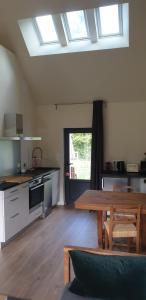 a kitchen with a wooden table and a dining room at Clairseine in Tournedos-sur-Seine