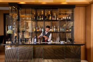 a man preparing a drink at a bar at Hotel Maison FL in Paris