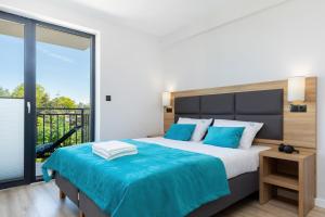 a bedroom with a large bed and a balcony at Morska 5 in Niechorze