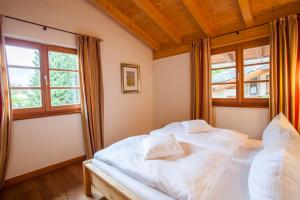 a bedroom with a white bed and a window at Haus am Katzenbach in Garmisch-Partenkirchen