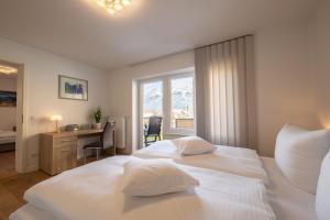 a bedroom with two beds and a desk and a window at Weitblick in Garmisch-Partenkirchen