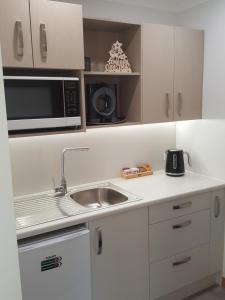 a small kitchen with a sink and a microwave at Above the River Karapiro Bed & Breakfast in Karapiro