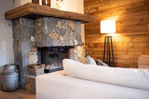 uma sala de estar com uma lareira de pedra e um sofá em Alpensinfonie em Garmisch-Partenkirchen