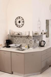 uma cozinha com um lavatório e um relógio na parede em Alandala Story em Cluj-Napoca