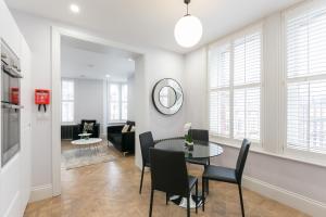 a dining room and living room with a table and chairs at Urban Chic - Shaftesbury in London