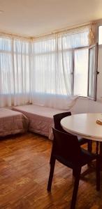 a bedroom with a bed and a table and a window at La Cañada Chascomús in Chascomús