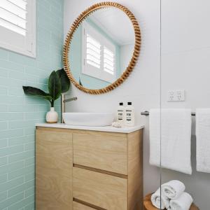 a bathroom with a sink and a mirror at The Bungalows at Bondi in Sydney