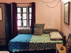 a bedroom with a bed and a window at Anjuna Hideout in Anjuna