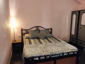 Un dormitorio con una cama con almohadas. en Anjuna Hideout en Anjuna