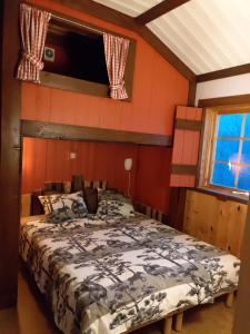a bedroom with a bed in a room with red walls at Mieps Huset Dalarna Holiday in Kullen