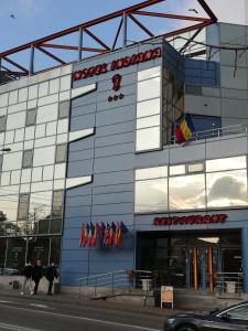 a building with people walking in front of it at Indiana Hotel in Iaşi