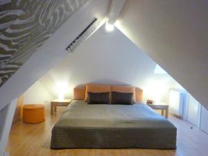 a bedroom with a large bed in an attic at Likedeeler Am Stadthafen in Lübeck