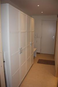 ガルミッシュ・パルテンキルヒェンにあるAlpenkiekerの白いキャビネット付きの部屋、ドア付きの廊下