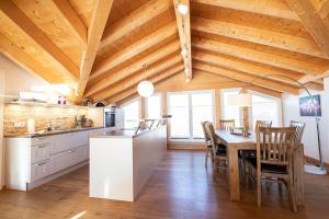 cocina con techo de madera y mesa con sillas en Bergzauber en Garmisch-Partenkirchen