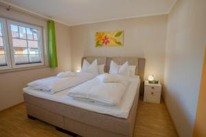Un dormitorio con una cama con almohadas blancas y una ventana en Hochstimmung, en Farchant