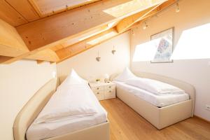 2 camas en una habitación con techos de madera en Bergzauber en Garmisch-Partenkirchen