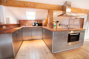 eine Küche mit Küchengeräten aus Edelstahl und Holzböden in der Unterkunft Auszeit Maisonette in Garmisch-Partenkirchen