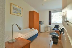 Habitación hospitalaria con cama, escritorio y silla en SKYAPPART Merseburg, en Merseburgo